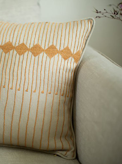 yellow cushion with embroidered stripes and diamond design
